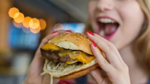 Getty Images Woman eating a burger