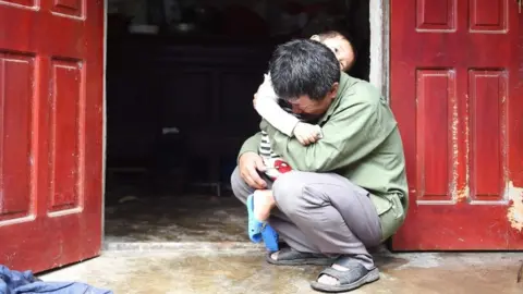Getty Images Le Minh Tuan, pictured here, fears his son, Le Van Ha, was among the dead in Essex