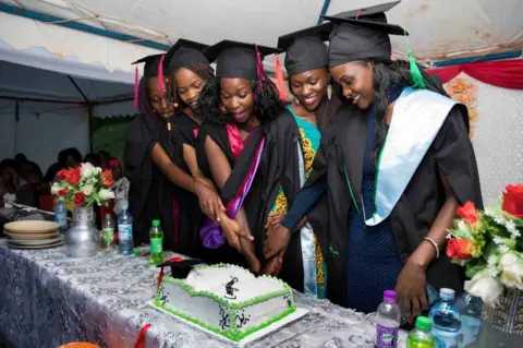AFP Ruth Akulu (right) and colleagues cut a cake together.
