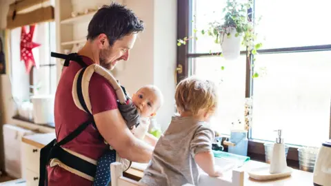 Getty Images A father with a baby and a toddler