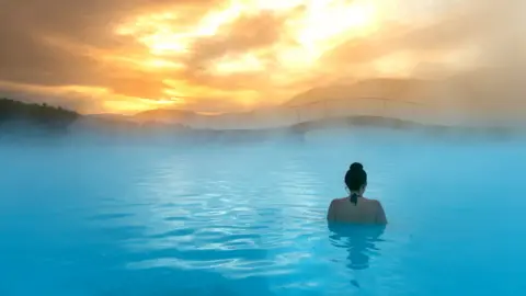 Getty Images Rear view of a woman standing in the Blue Lagoon, Iceland