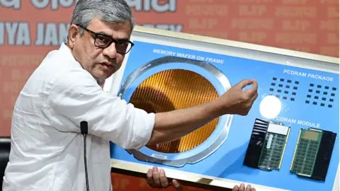 Getty Images Minister Ashwini Vaishnaw gives a demo of the complex, precision semi-conductor tech that Micron Technology is bringing to India during a press conference at BJP Headquarters in New Delhi on June 26, 2023.