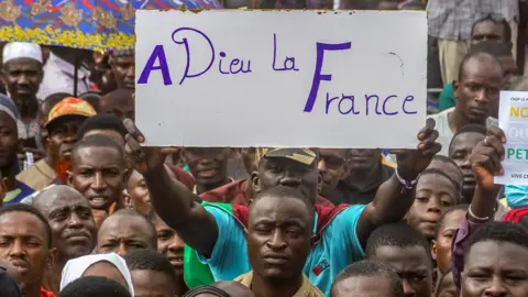 Reuters A man holds up a placard during a march in Niamey