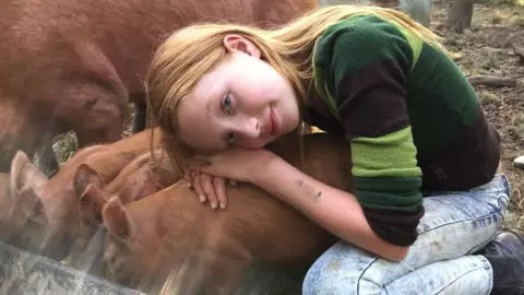 The Iris Project Iris hugging a pig