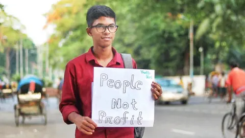 Yudhishtir Chandra Biswas 16-year-old Bangladeshi student Yudhishtir Chandra Biswas holds up a sign saying "people not profit"
