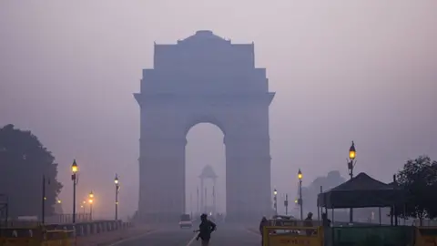 Getty Images Police officers stand guard at the India Gate monument shrouded in smog in New Delhi, India. Photographer: Prashanth Vishwanathan/Bloomberg