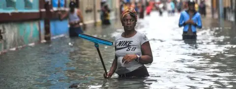 Getty Images Woman in floodwater in Havana