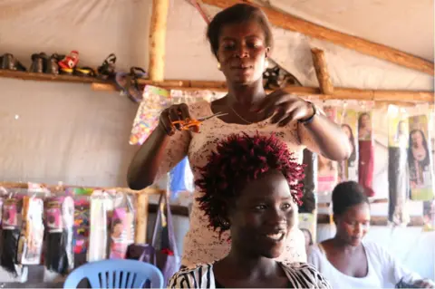 BBC Refugee entrepreneur Penina cutting hair