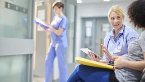 Getty Images Woman chatting to a female doctor