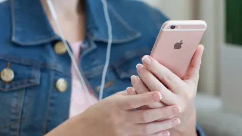 Getty Images A woman holding a rose gold iPhone 6S