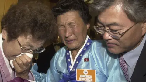 Getty Images Moon Jae-In (R), a senior aide to South Korean President Roh Moo-Hyun, and his mother (L) are engaged in a tearful reunion with Moon's aunt (C) from North Korea