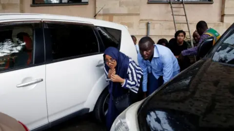 Reuters People are evacuated by a member of security forces at the scene where explosions and gunshots were heard at the Dusit hotel compound, in Nairobi, Kenya January 15, 2019.