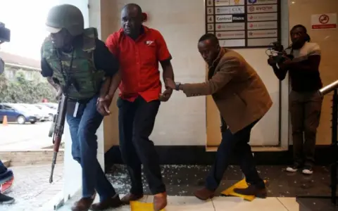 Reuters A man is evacuated by a member of security forces at the scene where explosions and gunshots were heard at the Dusit hotel compound, in Nairobi, Kenya January 15, 2019.