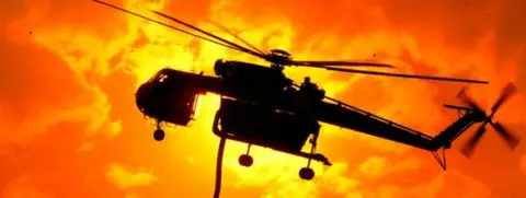 Getty Images A helicopter prepares to fight bushfires in Victoria's Bunyip State Park