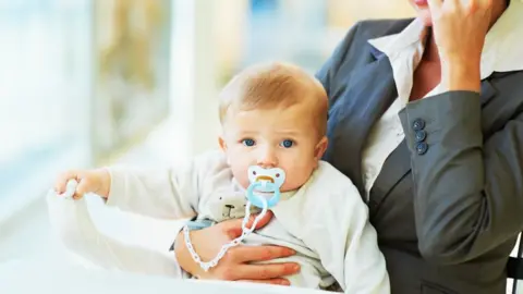 Getty Images/GlobalStock Baby with working mum