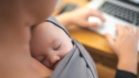 Getty Images/AzmanL Mother working with baby