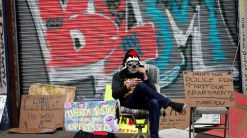 Reuters A demonstrator sits at the self-proclaimed Capitol Hill Autonomous Zone