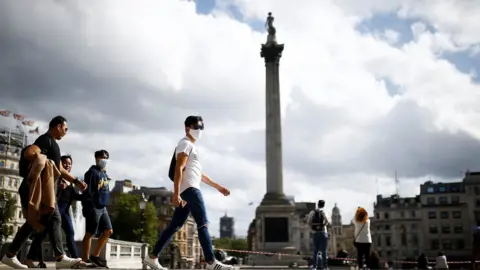 Reuters People wearing protective face masks walks through Trafalgar Square, amid the coronavirus (COVID-19) outbreak, in London, Britain, August 21, 2020. REUTERS/Henry Nicholls