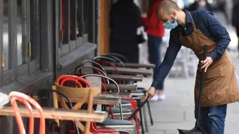 EPA Man cleans outside seating of London pub