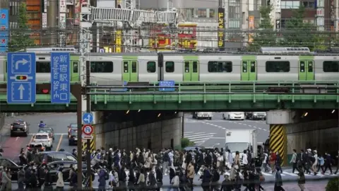 EPA Pedestrians cross a street at Shinjuku commercial, business and administrative centre in Tokyo, Japan, 18 November 2020.
