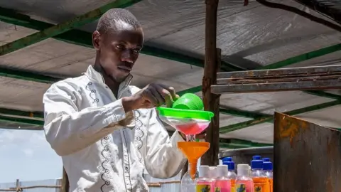 UNHCR Innocent Havyariama is seen bottling some soap