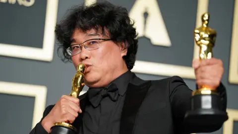 Getty Images Bong Joon-ho, winner of the Original Screenplay, International Feature Film, Directing, and Best Picture award for Parasite, poses in the press room during the 92nd Annual Academy Awards