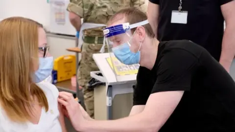 Ian Cooper Woman getting vaccine