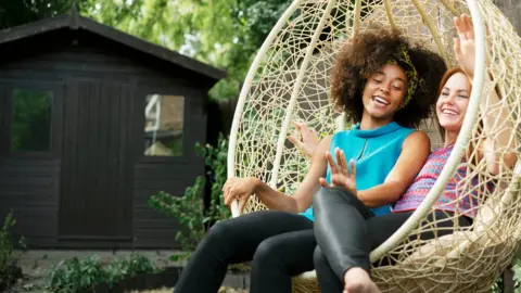Getty Images Two women on a swing seat