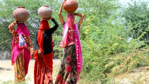 Getty Images Village women carry clay pots filled with drinking water to their homes from a public tap during a hot summer day, on the outskirts of Beawar.