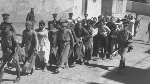 Getty Images British soldiers leading Arab prisoners in Palestine, 1938