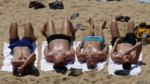 AFP/Getty Images People sunbathing on the beach