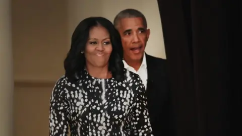 Getty Images Former President Barack Obama and his wife Michelle arrive for a roundtable discussion at the South Shore Cultural Center in Chicago, Illinois.