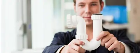 Getty Images A man holding an s-bend pipe