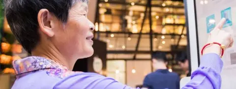 Getty Images Woman using screen to pay