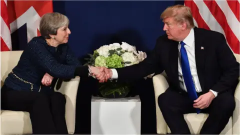 AFP Theresa May and Donald Trump shake hands at Davos