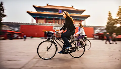 Living abroad can broaden your horizons. These two women cycle in Beijing. (Getty Images)