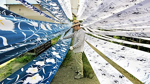 Getty Images A man looking at recycled garments (Credit: Getty Images)