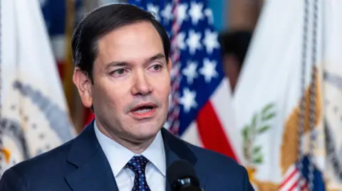 EPA Marco Rubio stands in front of flags