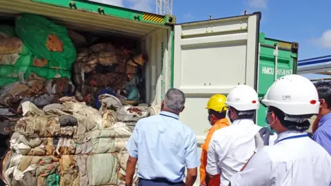 AFP In this handout picture provided by Sri Lankan Customs on July 23, 2019, customs officials inspect the load of a container at a port in Colombo