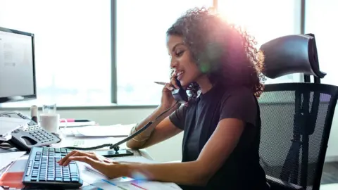 Getty Images Woman on the telephone at work