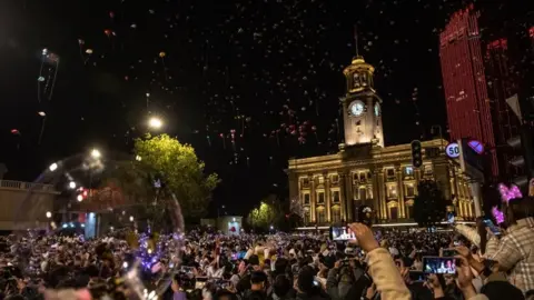 EPA Crowds celebrate outside Customs House Clock Tower in Wuhan