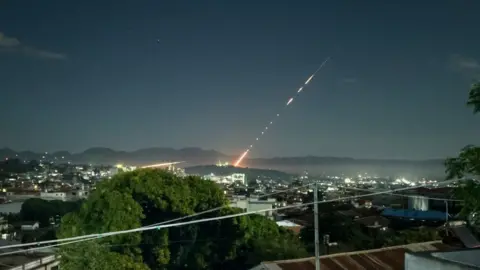 Getty Images This long exposure picture taken late on October 28, 2023 shows a missile fired from a Myanmar military base in Lashio township, northern Shan State. Heavy fighting between rebels and the Myanmar military stretched into a second day near the country's northern border with China, armed groups said on October 28, 2023