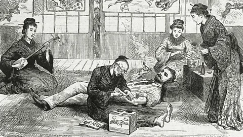 Pictorial Press Ltd/Alamy An artist tattoos a European visitor in Nagasaki, Japan in 1881 as geishas prepare tea (Credit: Pictorial Press Ltd/Alamy)