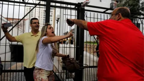 Reuters Supporters of Jair Bolsonaro (left) clash with a backer of the Workers' Party