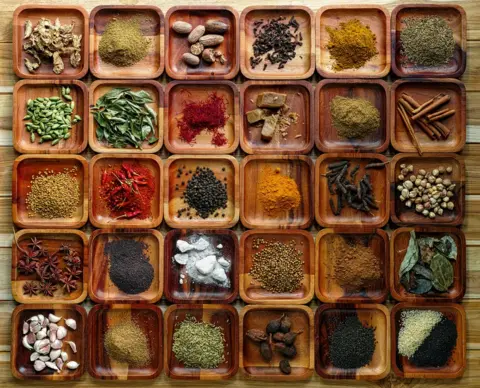 Getty Images Common Indian herbs and spice ingredients on wooden trays.