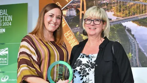 Bristol Film Office Two women smiling at the camera holding an award 