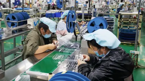 Getty Images Employees work at a Foxconn factory on September 4, 2021 in Zhongmu County, Zhengzhou City, Henan Province of China.