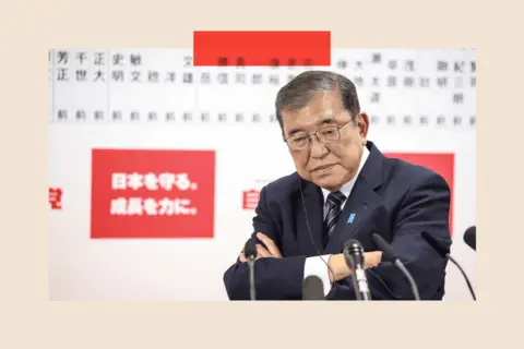 EPA Shigeru Ishiba folds his arms and speaks to the media via multiple microphones