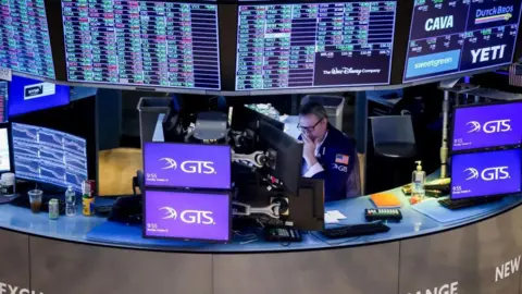 Getty Images A sole trader surrounded by screens on the floor of the New York Stock Exchange