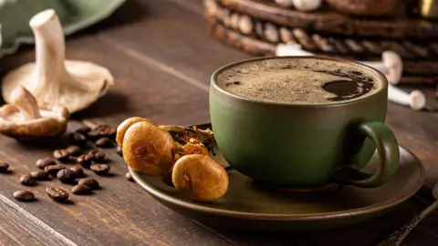 Getty Images Trendy superfood mushroom coffee in green cup on wooden background. 